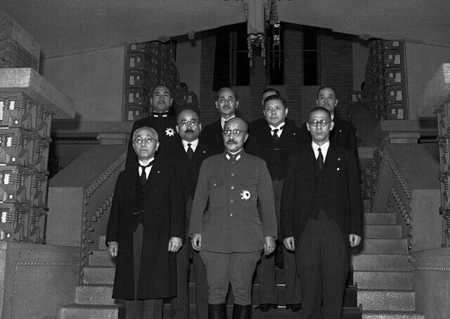 Hideki Tojo standing on stairs surrounded by his cabinet