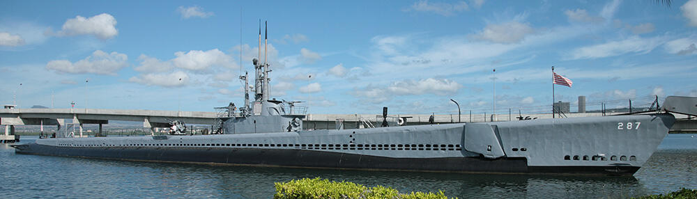 Full side view of the USS Bowfin Submarine docked at Pearl Harbor National Memorial.