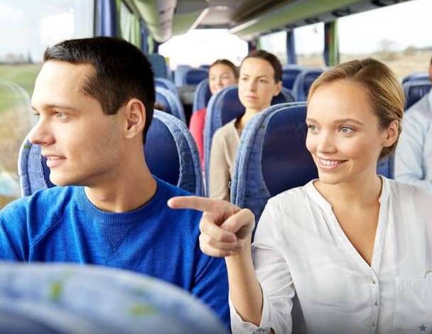 Guests looking out of the windows of a tour bus.